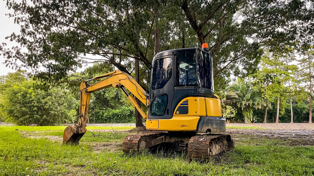 Compact excavator working precisely in a park and landscaping setting